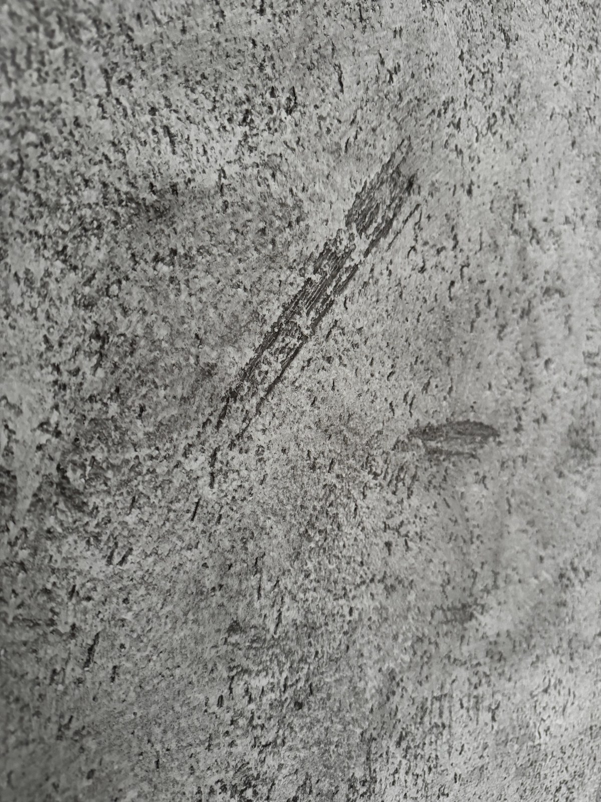 Detail ruční kresby šedé stěrky v šikmém světle